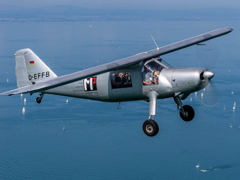 Ein kleines Propellerflugzeug fliegt über den Bodensee.