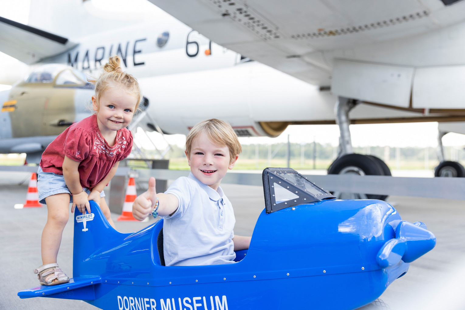 Zwei Kinder spielen mit Spielzeugflugzeug im Dornier Museum