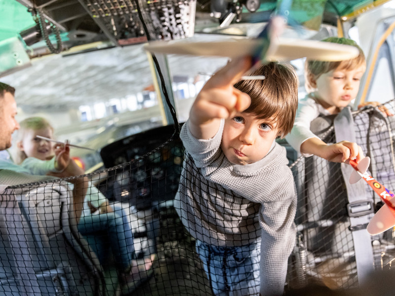 Kinder spielen in Cockpit eines Exponats