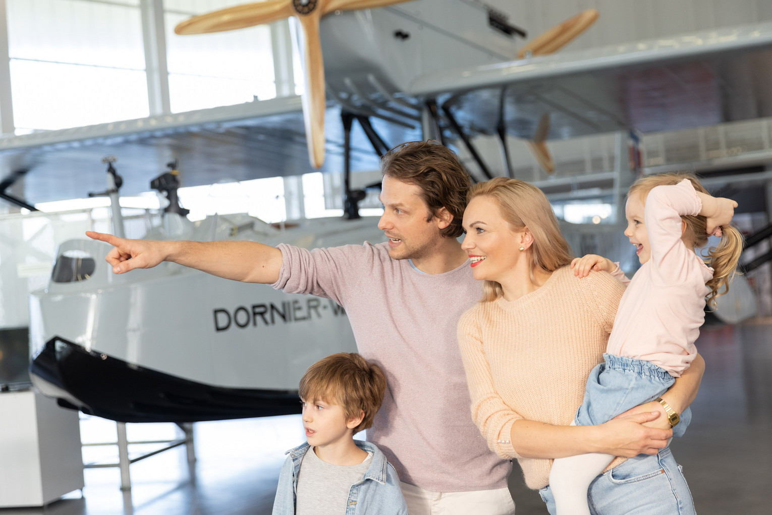 Familie erkundet eine Ausstellung mit historischen Flugzeugen im Dornier Museum.