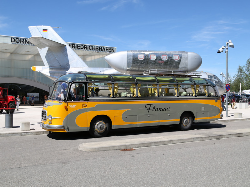 Ein gelber Shuttlebus steht vor einem Flugzeug auf dem Rollfeld.